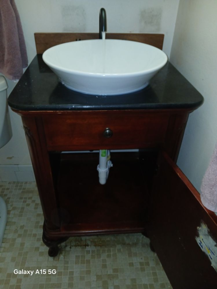 Vessel bowl sink on black granite top with dark antique wood vanity